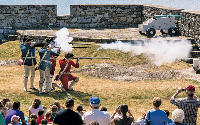 Men firing rifles during battle reenactment