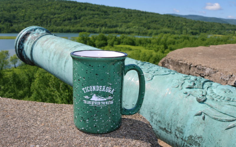 Coffee mug next to cannon on Fort Ticonderoga wall with blue skies